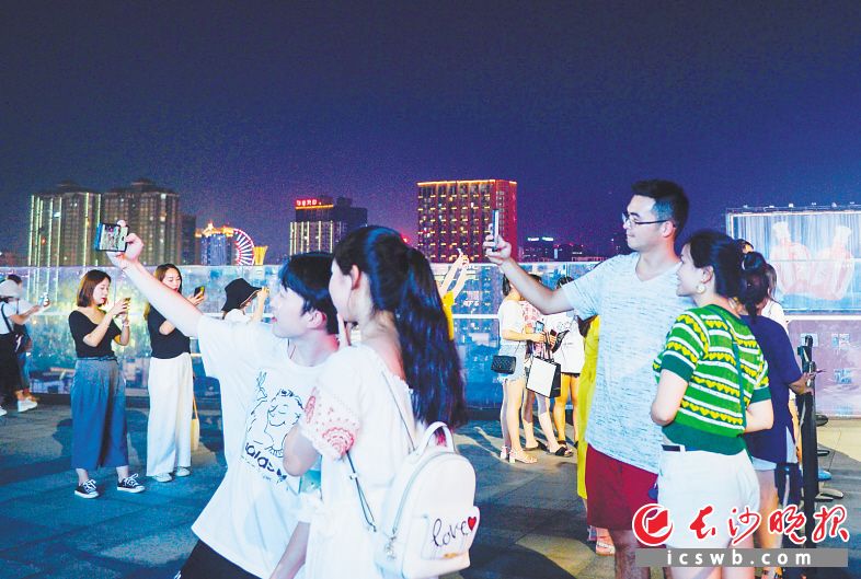 在长沙国金中心7楼平台,游客们正在拍照。