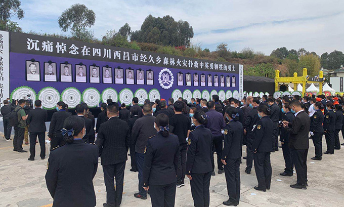 手捧鲜花肃穆站立，西昌市民自发前往殡仪馆送别扑火英雄