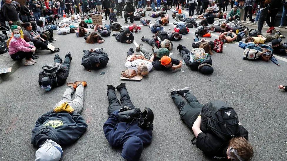 ▲当地时间5月27日,美国波特兰,示威者以弗洛伊德生前最后9分钟的姿势伏地抗议。图据BBC