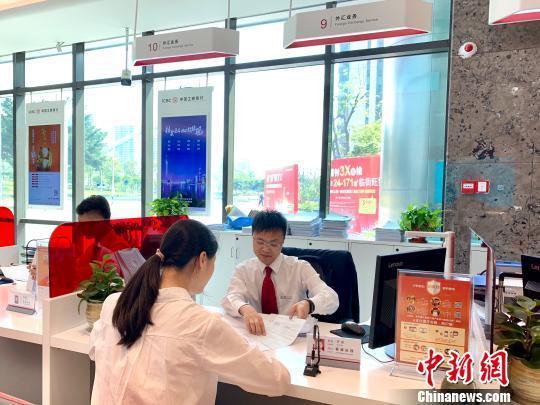 资料图:银行工作人员正在为客户服务。 赵玎 摄