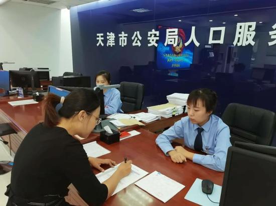 天津市民政局事业处工作人员朱娜(左一)在天津市公安局人口管理总队为受助人员办理落户手续。受访者供图