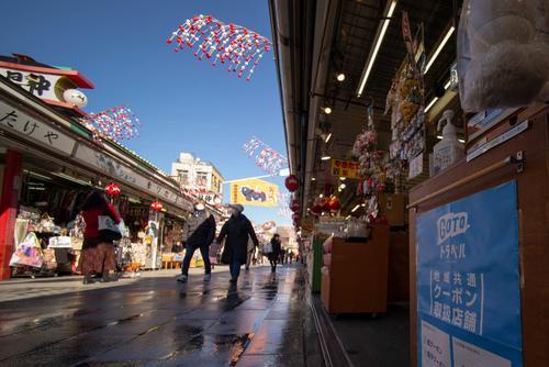 ▲12月15日,东京浅草寺附近拍摄的“去旅行”旅游补贴项目的宣传牌(右)。 | 新华社发
