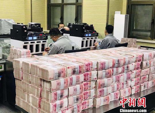资料图:银行工作人员在点钞。艾庆龙 摄