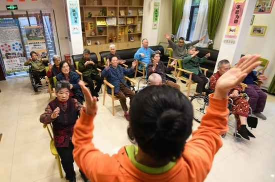2021年4月,在贵阳市南明区油榨街道晚霞彩带老年人日间照料中心,工作人员带领老年做保健操。